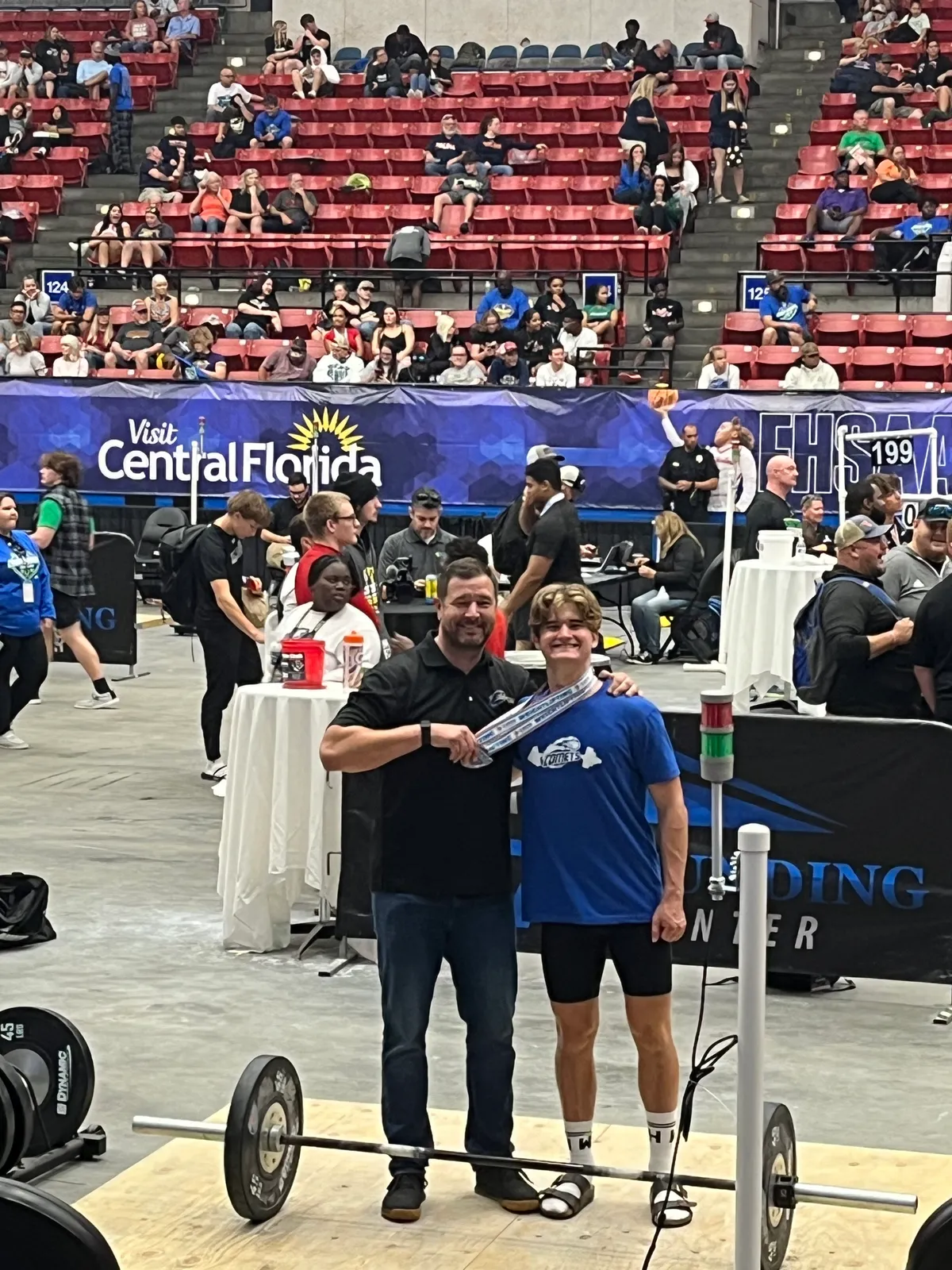 Coach Joe Thomas presenting Will Higgins with his medals at the FHSAA Weightlifting State Championship